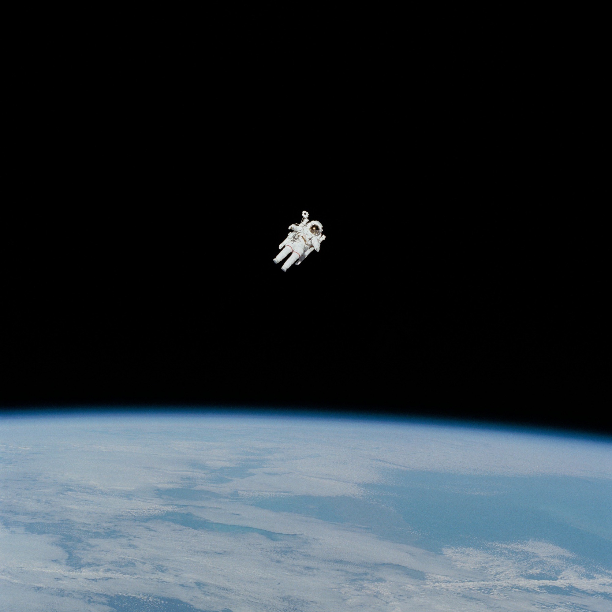 An astronaut floating in space above Earth with comets or clouds in the background.