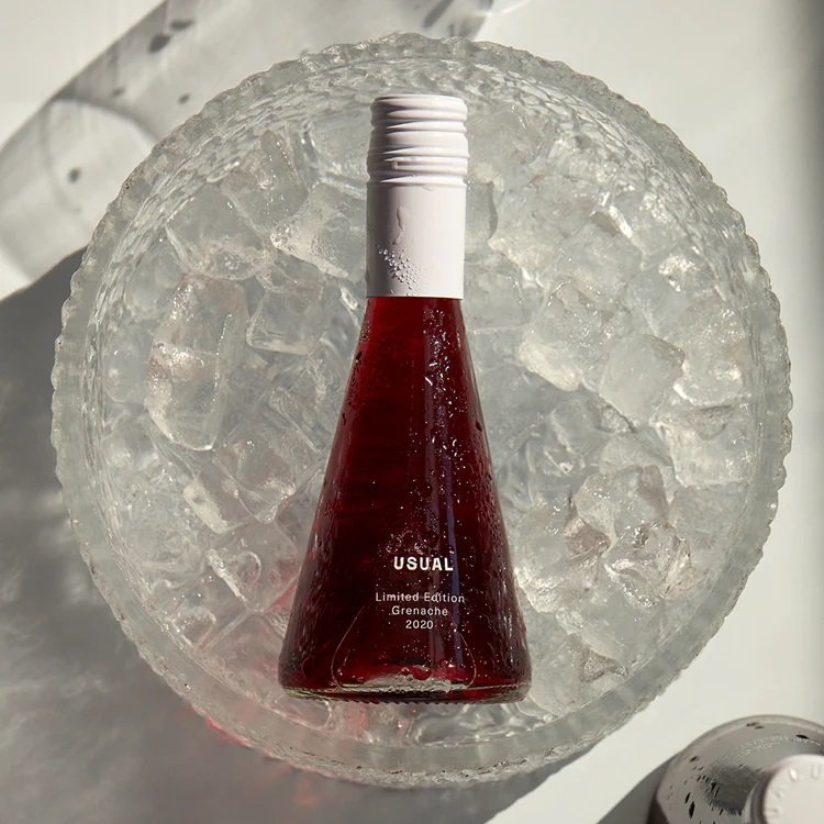 Usual red wine bottle placed in a bowl of ice water