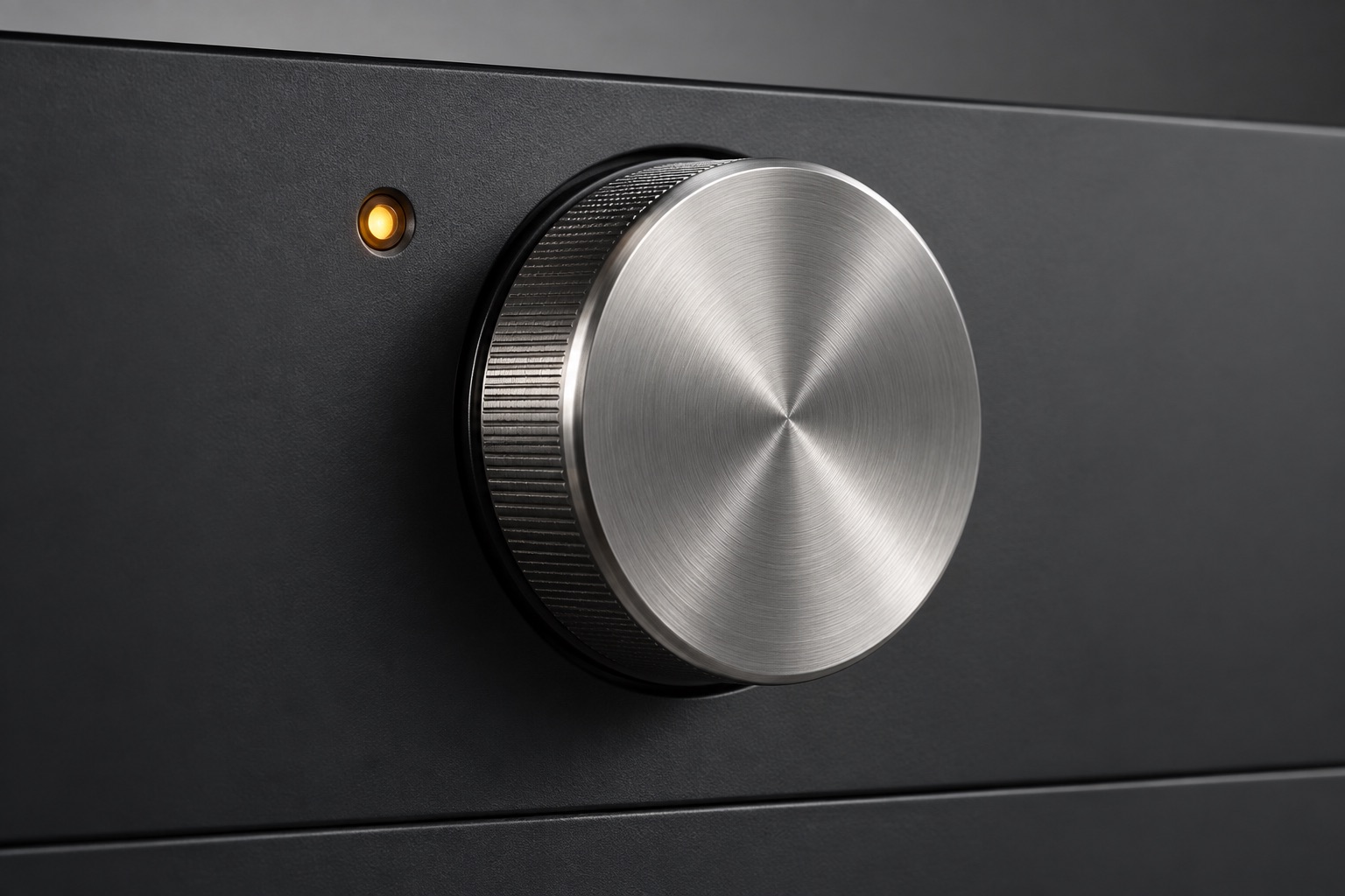 Conceptual appliance panel with a textured metal dial and an amber indicator light.