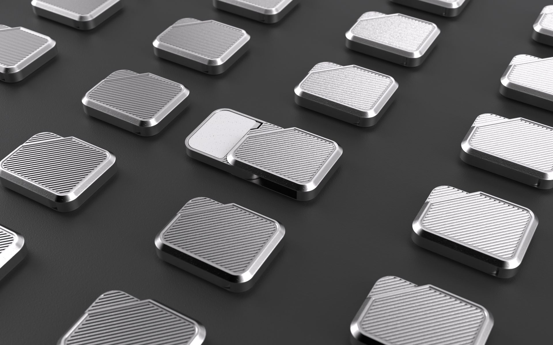Multiple silver metallic square objects with textured patterns on a black surface.