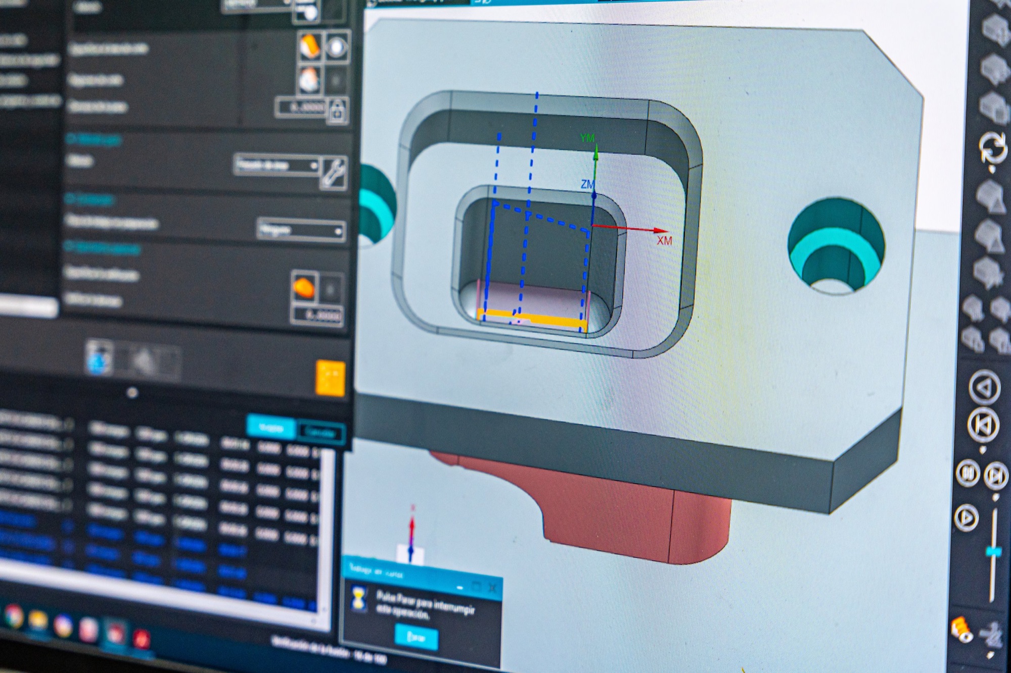 Computer screen displaying 3D CAD modeling software with a mechanical part in gray and red, surrounded by various toolbars and interface elements.