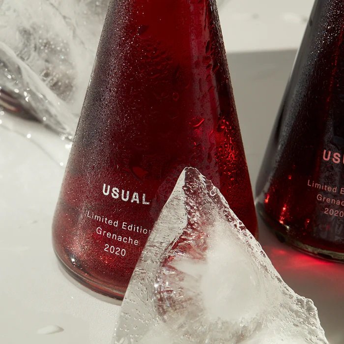 Two limited edition USUAL Grenache 2020 bottles with ice in the foreground.