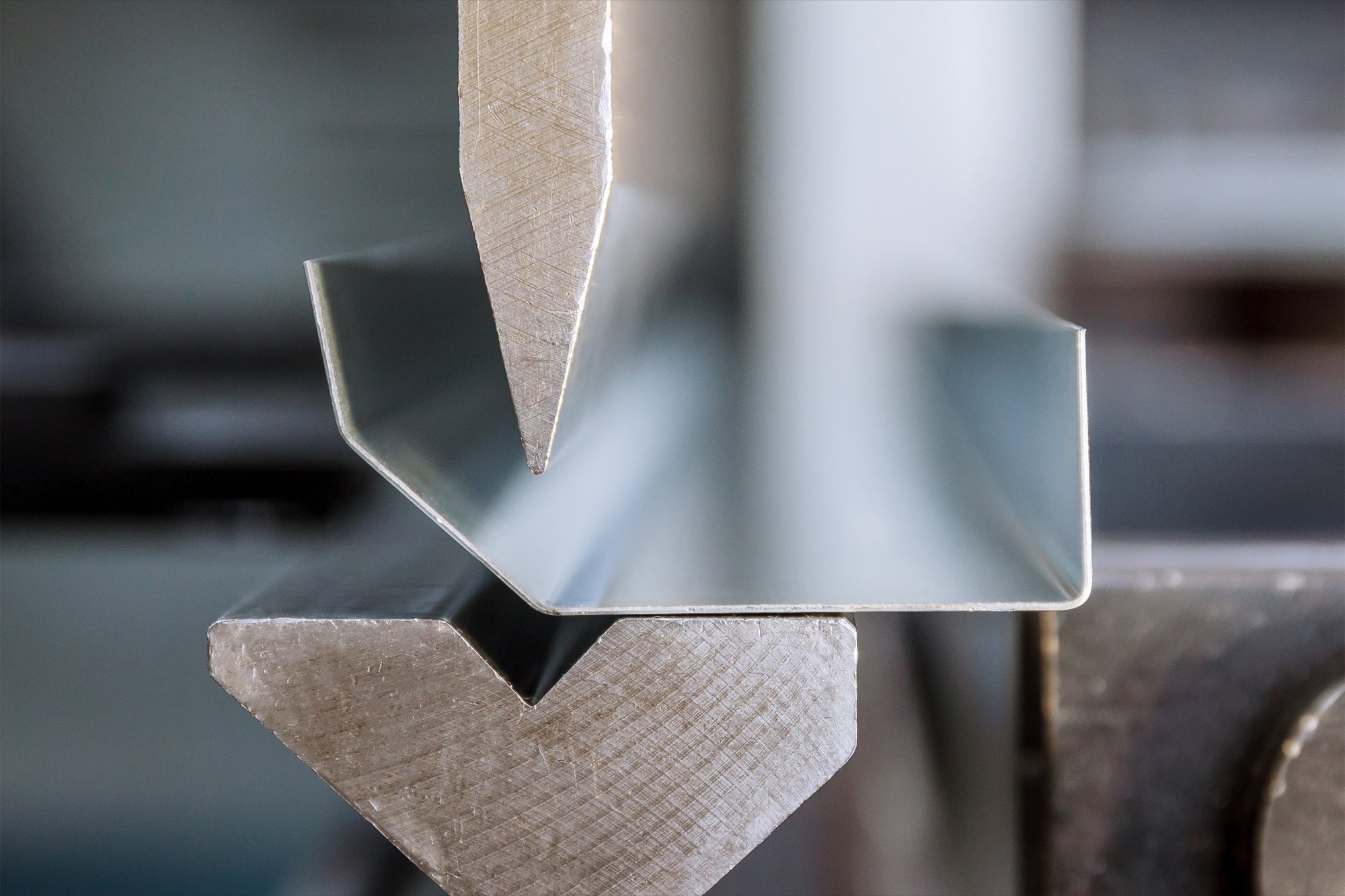 Close-up of metallic metal angles or channels, arranged in a layered pattern, with a focus on the textured edges.