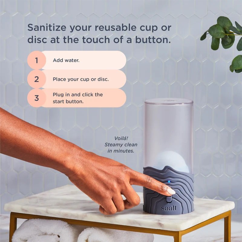 Hand pressing start on Saalt Menstrual Cup Steamer with cup inside